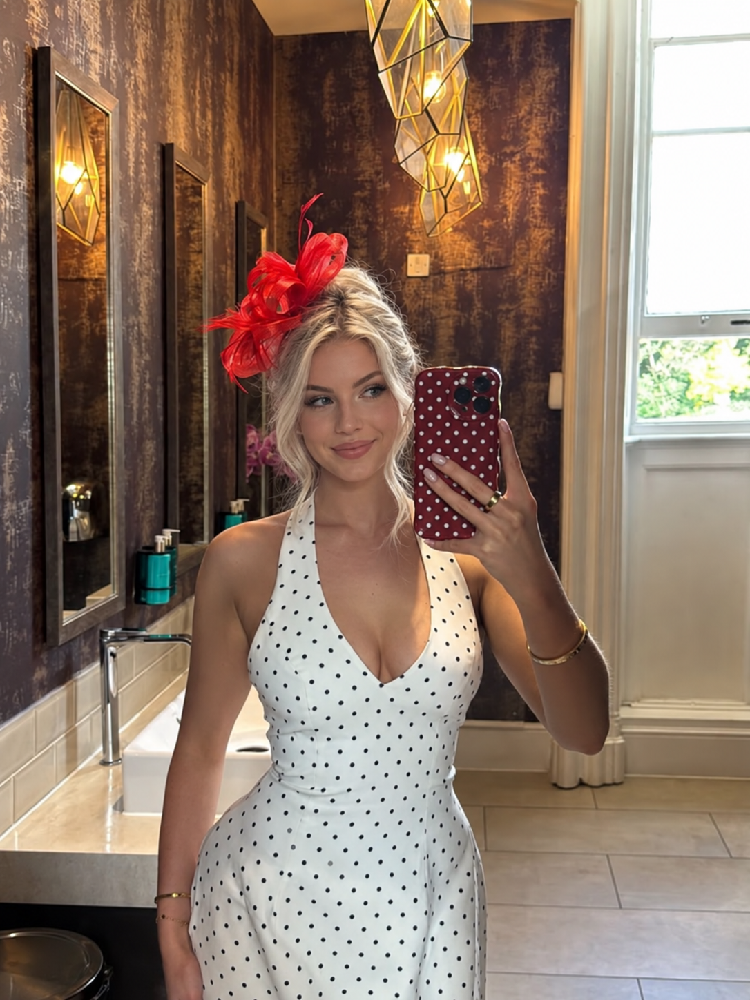 Arabella in a polka-dot dress and red fascinator