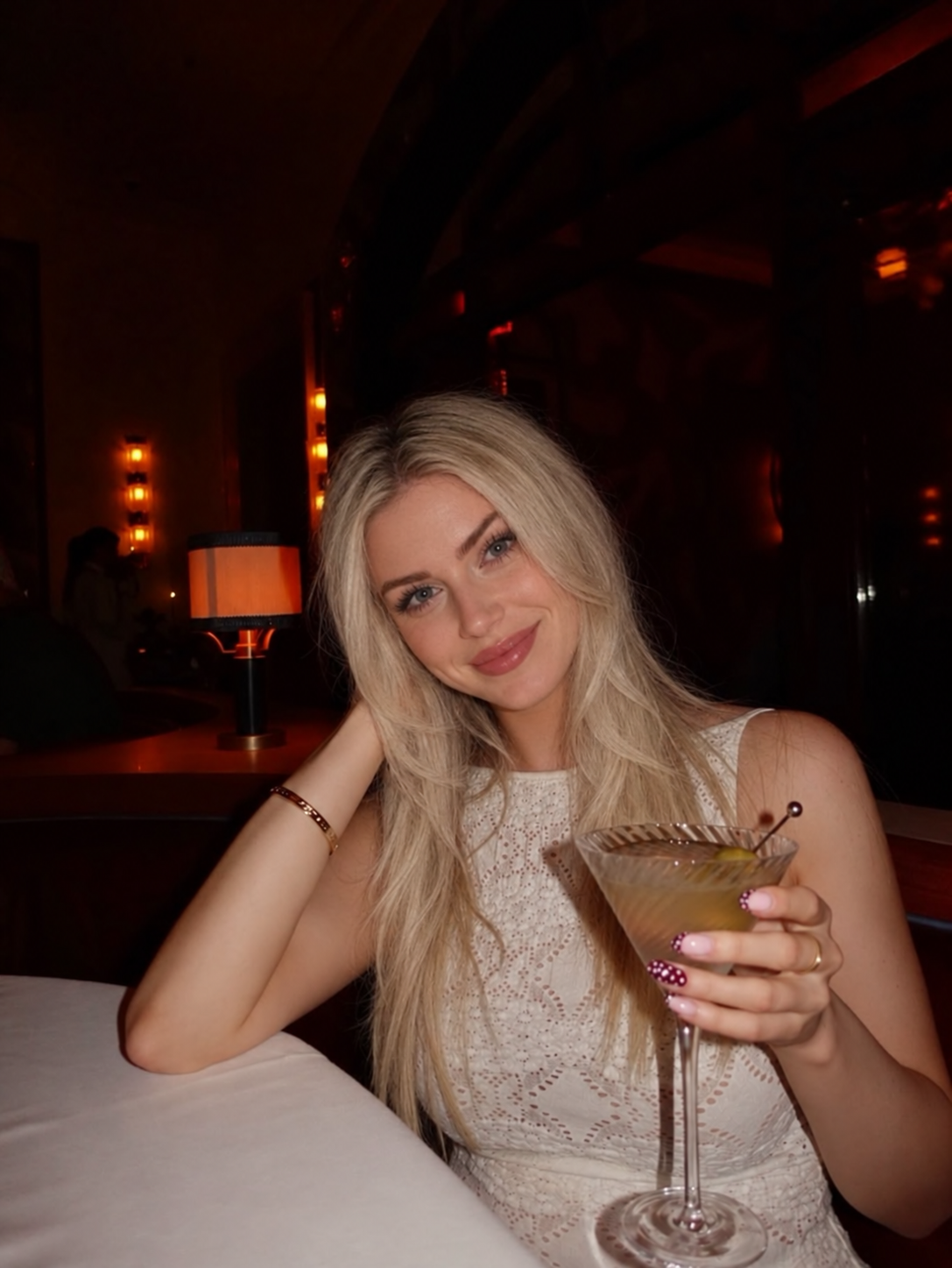 Arabella wearing white lace at a dinner table