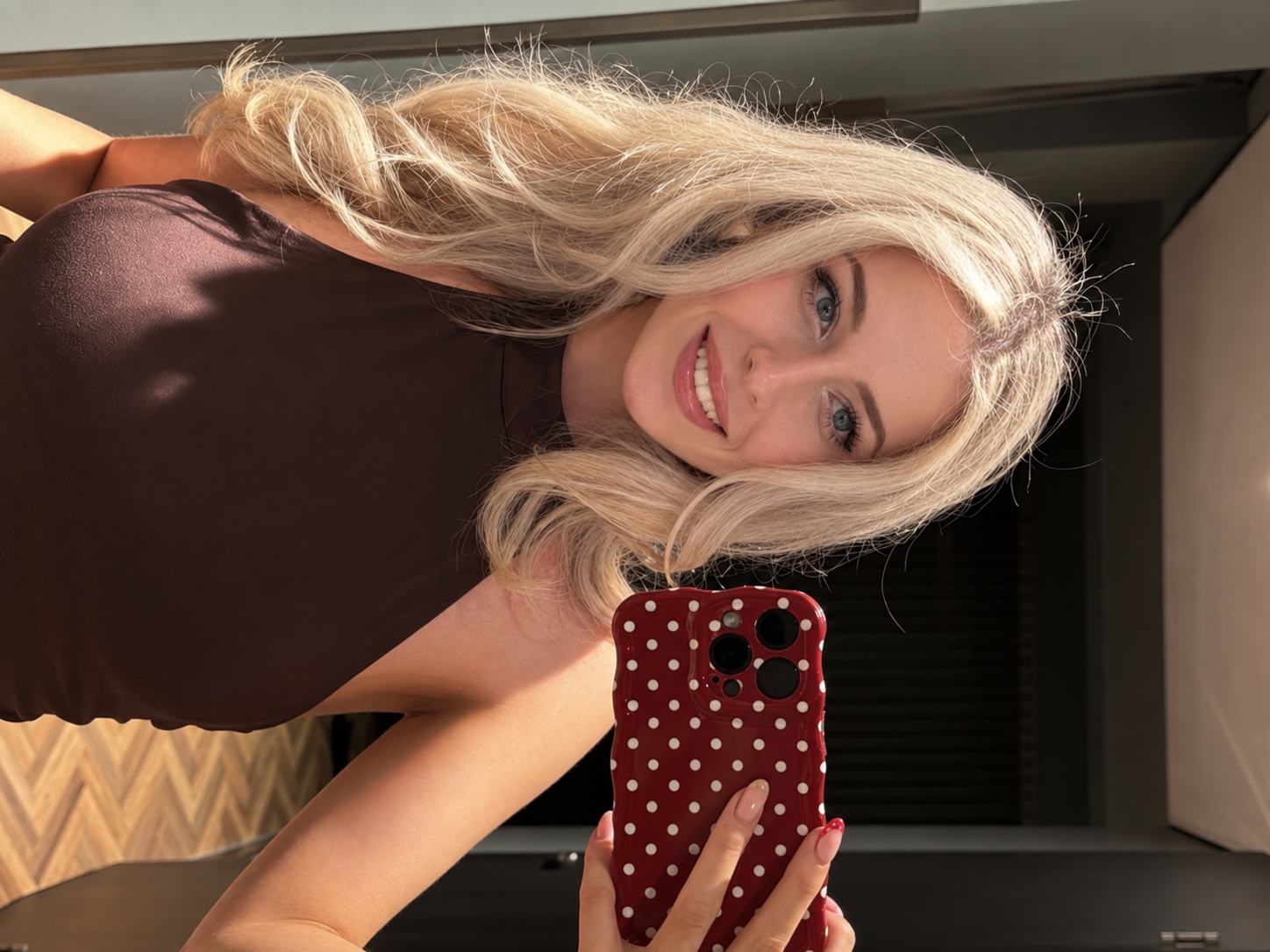 Arabella taking a mirror selfie in a chocolate-brown halter top
